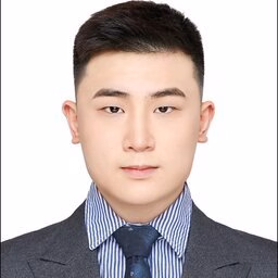 Headshot photograph of a young man in suit and tie against white background